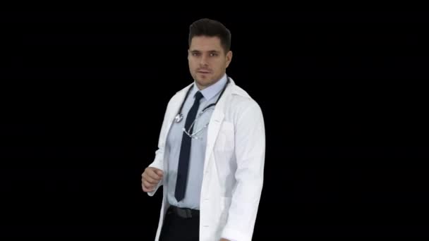 Szczęśliwy lekarz pokazuje coś blisko niego i uśmiecha się, Alpha Channel — Wideo stockowe