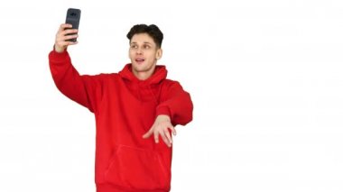 Heyecanlı rahat adam dans ve beyaz arka plan üzerinde telefonu ile selfie yapma.