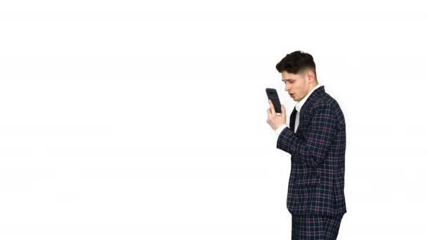 Молодой бизнесмен танцует после ссоры по телефону на белом фоне . — стоковое видео