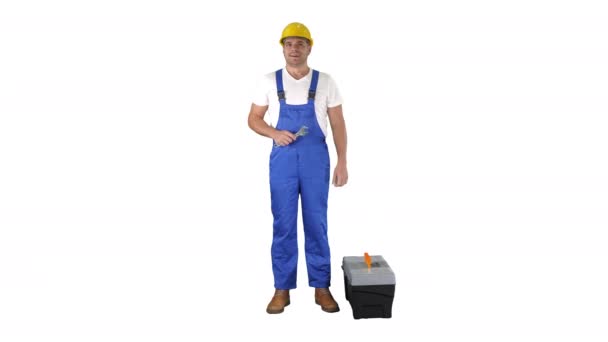Een reparateur met een gereedschapskist en een moersleutel die glimlacht naar de camera op een witte achtergrond. — Stockvideo