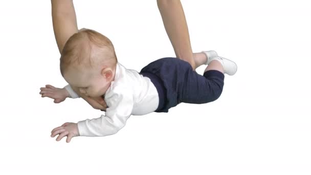 Baby lays on his stomach and holds his head on white background. — Stock Video