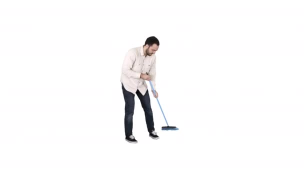 Ung man rengöring golv med borste på vit bakgrund. — Stockvideo
