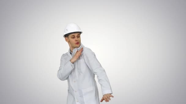 Legrační scientinst v bílém rouchu a bezpečnostní přilbě tančící na přechodových pozadí. — Stock video