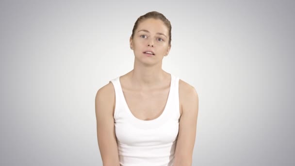 Souriante fille au repos après l'entraînement de yoga et de parler à quelqu'un sur fond de dégradé . — Video