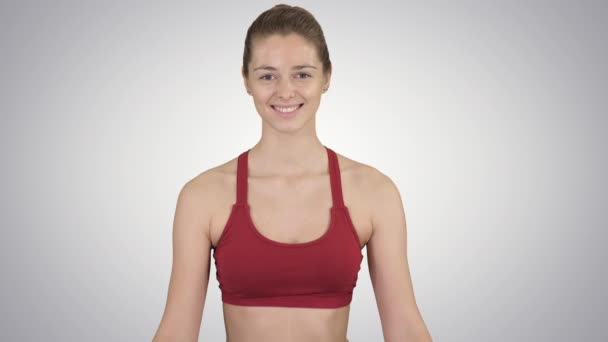 Женщина практикует медитацию йоги, улыбаясь на градиентном фоне. — стоковое видео