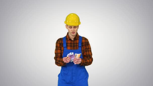 A workman counting cash in exaggerated way and dancing after that on gradient background. — Stock Video