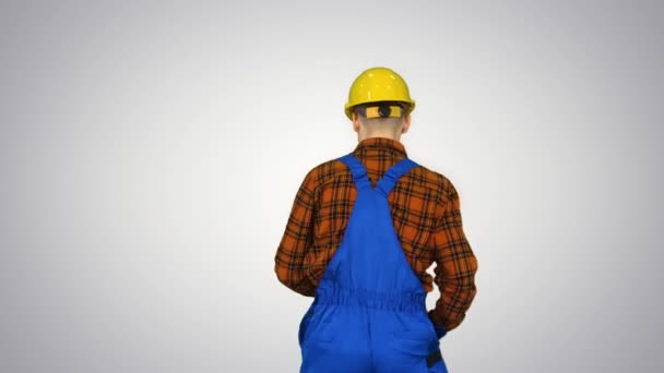 Trabajador de la construcción en casco bailando sobre fondo degradado . — Vídeo de stock
