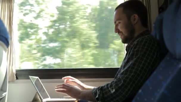 Ενθουσιασμένος άνθρωπος που ελέγχει την εργασία σε ένα tablet στο τρένο είναι ικανοποιημένος με το αποτέλεσμα. — Αρχείο Βίντεο