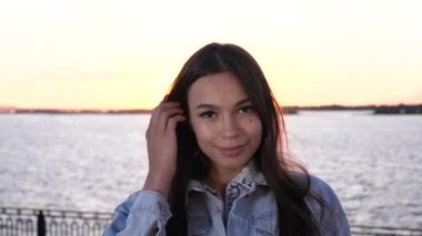 Gülümseyen ve kameraya bakan neşeli bir kadın..