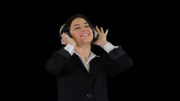 Young business woman listening to music in headphones and dancing, Alpha Channel — Stock Video