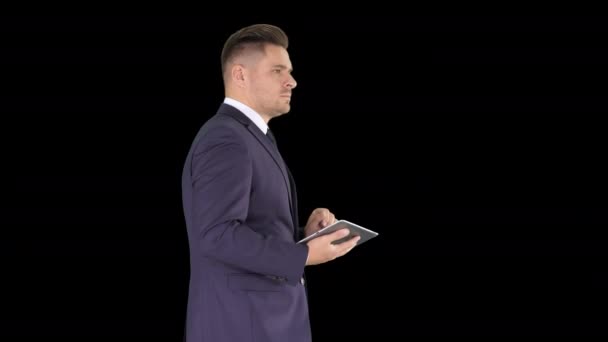 Elegáns fiatal üzletember segítségével a PC tabletta járás közben, Alpha Channel — Stock videók