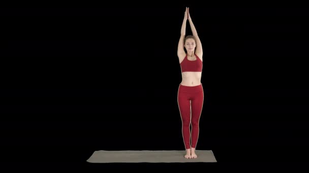 Женщина практикующая йогу, стоящая в упражнении "Расширенный угол", поза парсваконасана Уттхиты, канал Альфа — стоковое видео
