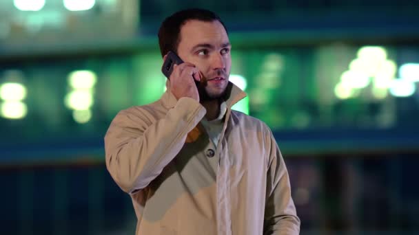Empresário fazendo uma chamada por celular ao ar livre à noite . — Vídeo de Stock