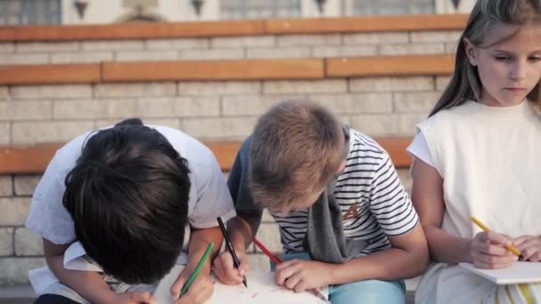 Två flickor och två pojkar ritar med filtpennor. — Stockvideo