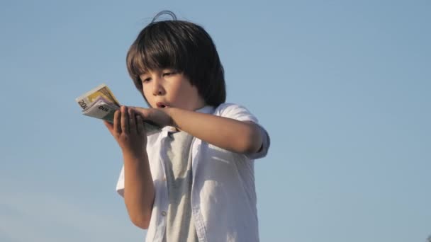 Leuke jongen gooit met geld eurobankbiljetten. — Stockvideo