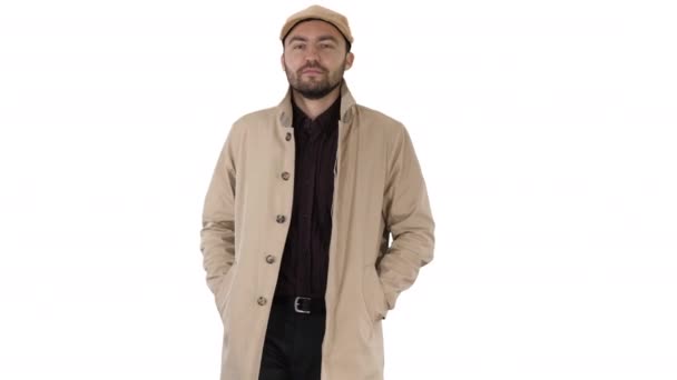 Confident man in trench holding hands in the pockets and walking on white background. — Stock Video