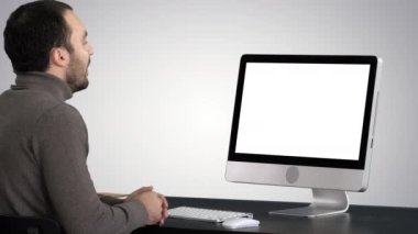 Genç İşadamı bilgisayarında gradyan arkaplan üzerine video görüşmesi yapıyor.