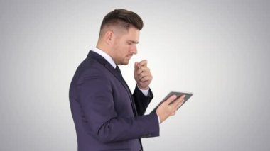 Degrade arka planda teknoloji tableti kullanan akıllı kıdemli işadamı.
