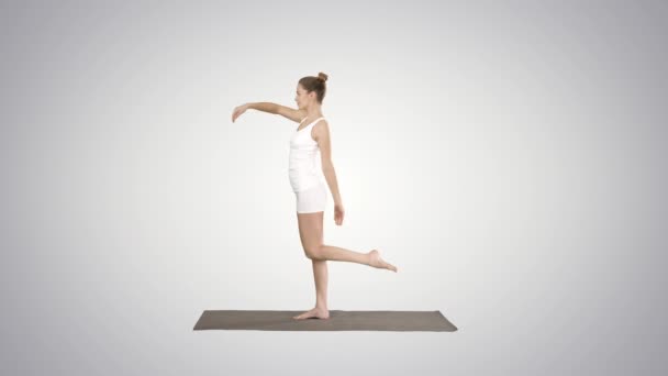 Young yogi attractive woman practicing yoga concept, standing in Natarajasana exercise on gradient background. — Stock Video