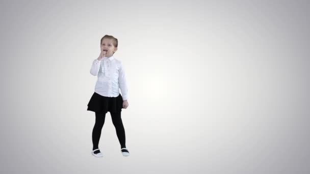 Linda chica feliz cantando en el micrófono imaginario en el fondo gradiente . — Vídeos de Stock