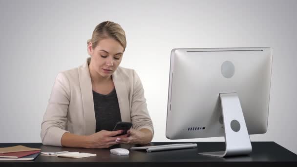 Frau benutzt Handy am Schreibtisch auf Steigungshintergrund. — Stockvideo