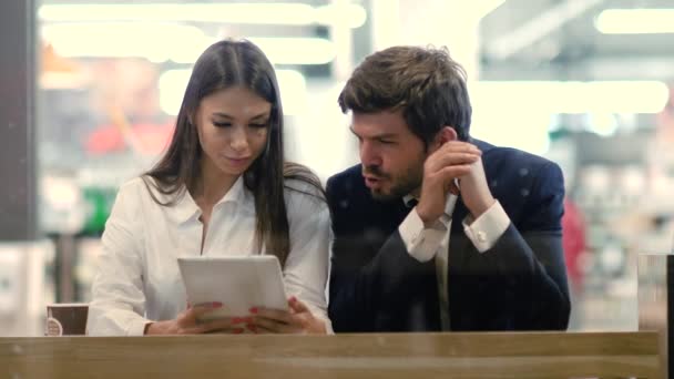 Casal de negócios usando um tablet enquanto eles têm uma pausa para o café. — Vídeo de Stock
