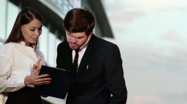 İş adamı ve kadın kağıtları tartışır..