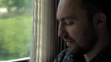 Adam aramayı bitirir ve trenin penceresinden bakar..