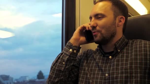 Молодой кавказский мужчина в поезде метро разговаривает по мобильному телефону. — стоковое видео