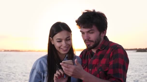 Ευτυχισμένο ζευγάρι κάνει online ψώνια στο τηλέφωνο σε εξωτερικούς χώρους. — Αρχείο Βίντεο