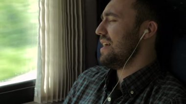 Trende şarkı söyleyen genç adam..