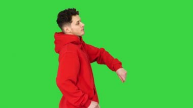 Yeşil ekranda kırmızı kapüşonlu dans eden yakışıklı genç adam, Chroma Key.
