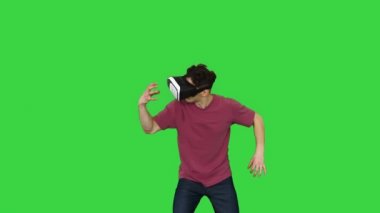 Yeşil Ekran, Chroma Key 'de sanal gerçeklik dünyasına dokunan ve etkileşen VR kulaklık kullanan inanılmaz bir adam..