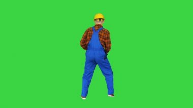 Miğferli inşaat işçisi yeşil ekranda dans ediyor, Chroma Key.