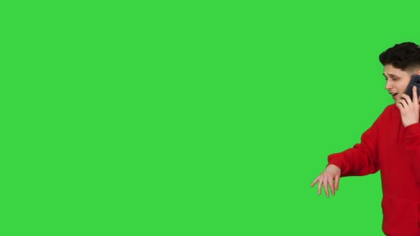 緑の画面、クロマキーの上を歩くと電話で話して踊るカジュアルなヒップホップの男. — ストック動画