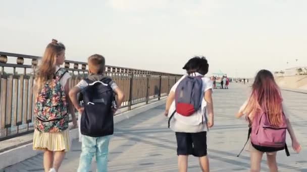 Dos niños y dos niñas regresan a casa después de que la escuela salta y corre . — Vídeo de stock