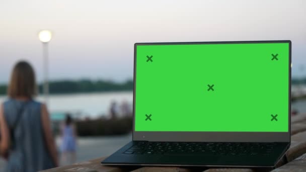 Young couple of man and woman walking. Laptop on a bench with blank screen. — Stock Video