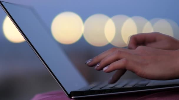 Mani femminili che lavorano sul computer portatile nelle luci serali . — Video Stock