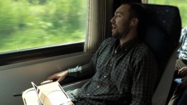 Genç adam trende müzik dinliyor ve şarkı söylüyor..