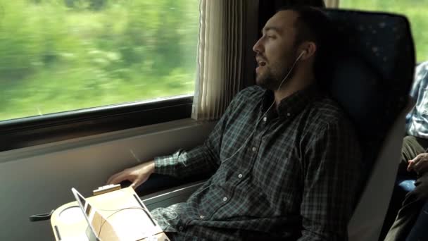 Jongeman die luistert naar de muziek in de trein en zingt. — Stockvideo