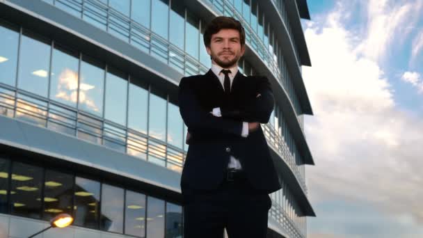 Alegre hombre de negocios guapo en ropa formal de pie con las manos dobladas . — Vídeo de stock