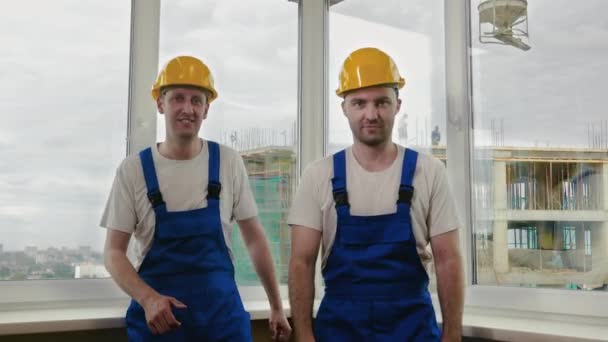 Bauarbeiter tanzen lustig in Helmen. — Stockvideo