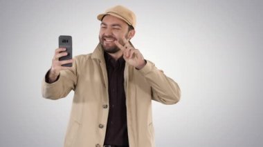 Genç yetişkin adam yakışıklı degrade arka planda selfie alarak.