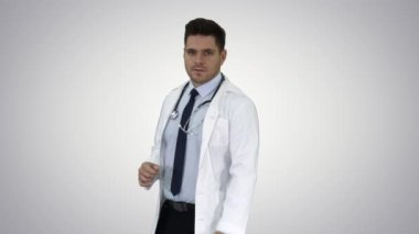Ona yakın bir şey gösteren ve degrade arka planda gülümseyen mutlu doktor.