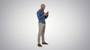 Rahat Arap işadamı telefonu kullanarak ve degrade arka planda gülümseyen.
