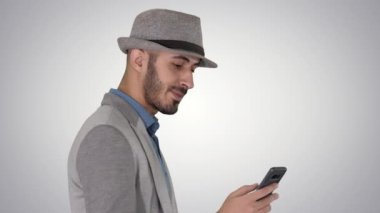 Sıradan bir adam telefonda mesajlaşıyor ve değişken bir arkaplanda yürüyor..