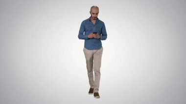 Gradyan arkaplan üzerinde yürürken mesaj gönderen adam.