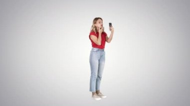 Sarışın kadın degrade arka plan Smartphone'da önünde bakıp.