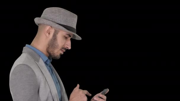 En seriøs arabisk mann som bruker smarttelefon mens han går, Alpha Channel – stockvideo