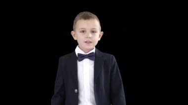 Takım elbiseli arkadaş canlısı küçük çocuk merhaba diyor ve sonra güle güle, Alfa Kanalı diyor.